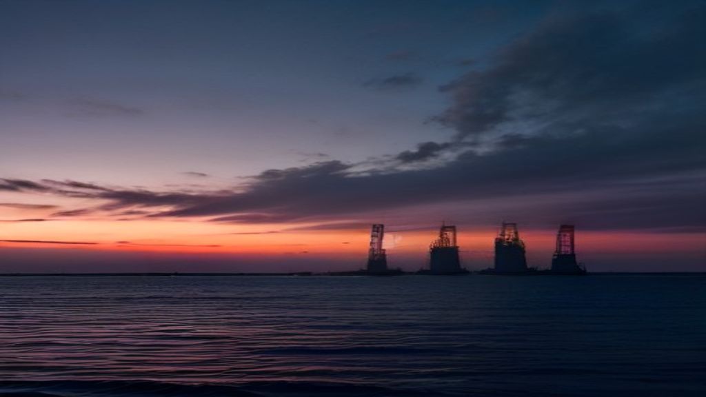 Oil refinery at sunset with flare stacks